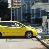 Pesquisa sobre carro elétrico: Nissan Leaf amarelo, táxi com emissão zero, sendo carregado em eletroposto BR no Rio de…