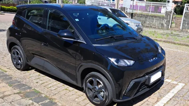 BYD Dolphin Mini ou Renault Kwid E-Tech: Dolphin Mini preto estacionado em rua de paralelepípedos no Brasil