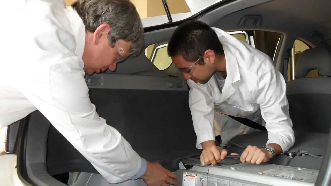 Engenheiros instalam uma bateria de carro elétrico maior no porta-malas de um híbrido plug-in, em teste de recarga na tomad…
