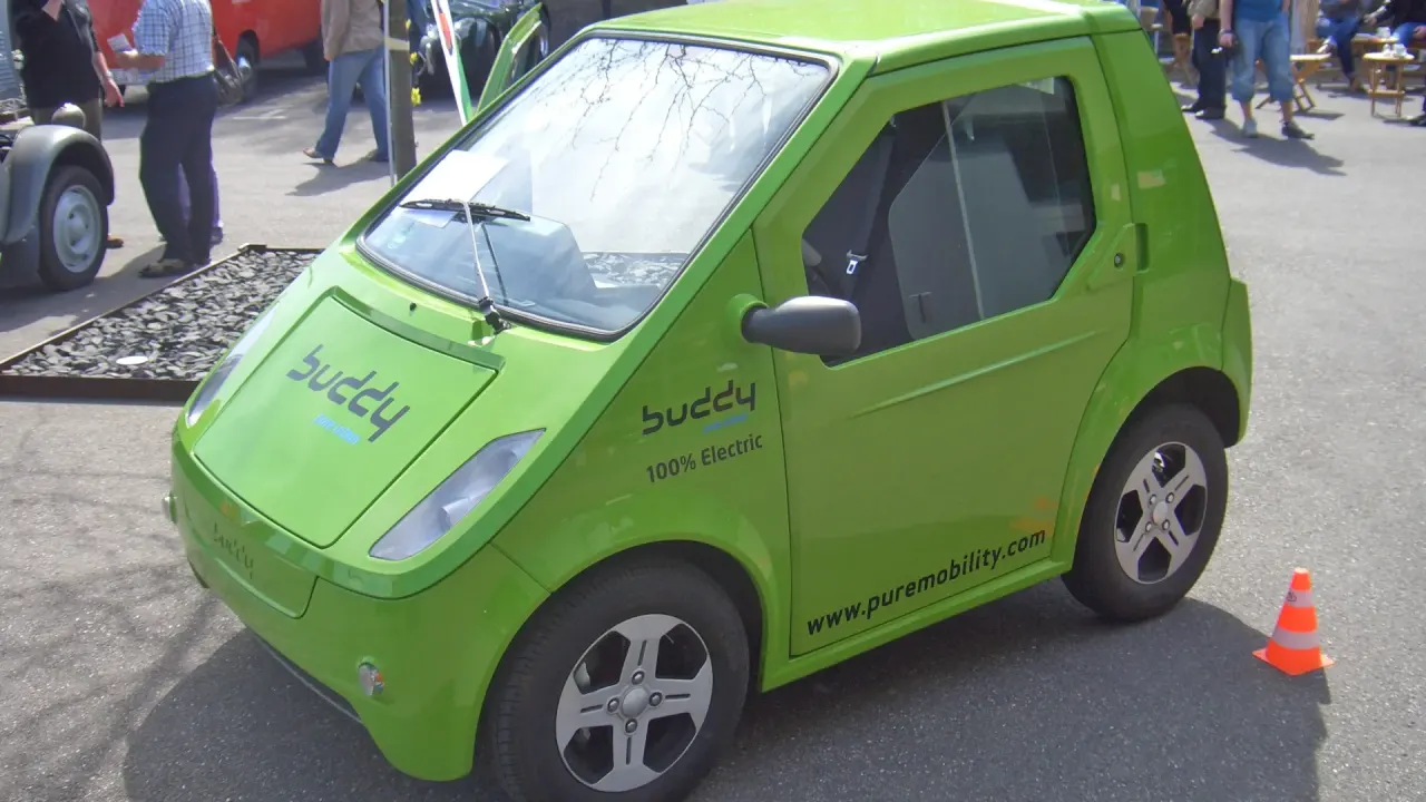 Carro elétrico de R$ 65 mil: compacto verde 100% elétrico Pure Mobility Buddy estacionado, visto de frente e lateral