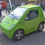 Carro elétrico de R$ 65 mil: compacto verde 100% elétrico Pure Mobility Buddy estacionado, visto de frente e lateral