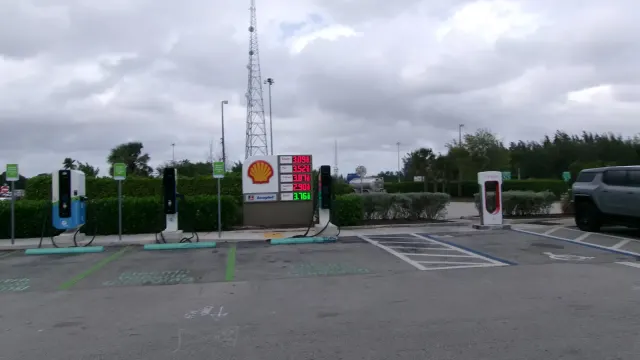 Posto com carregadores de carro elétrico ao lado de bombas de preço de gasolina: carro elétrico ou a gasolina, qual sai mai…